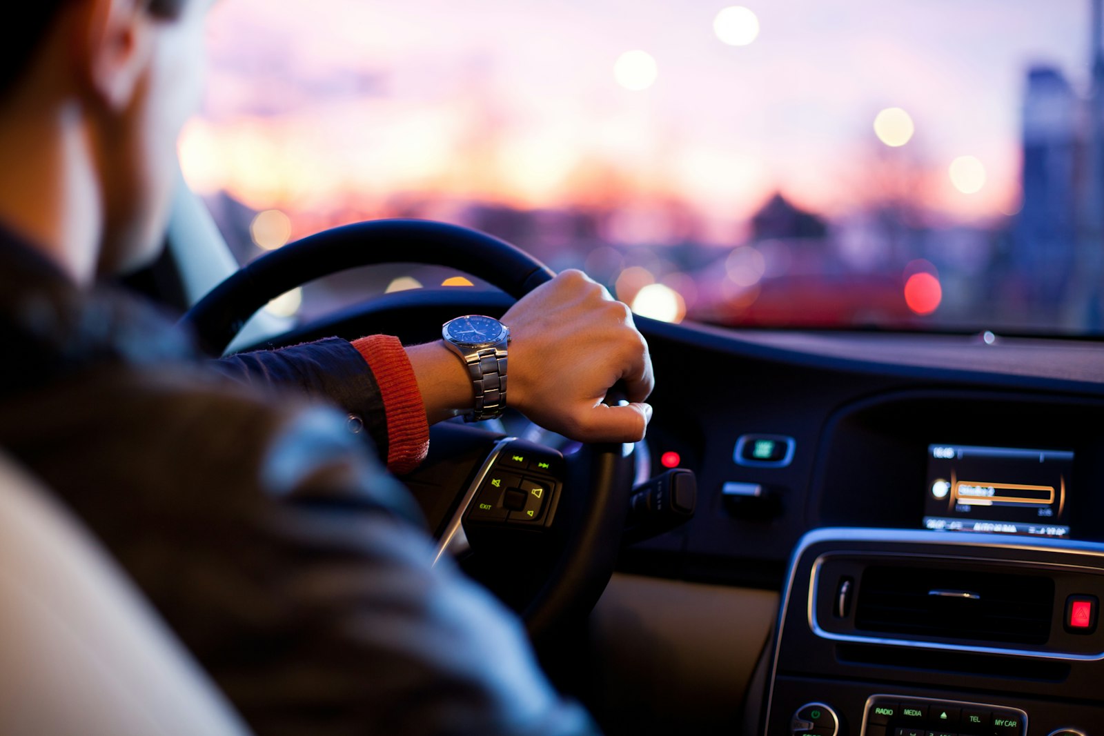 Driver checking arrival time on the road at dusk