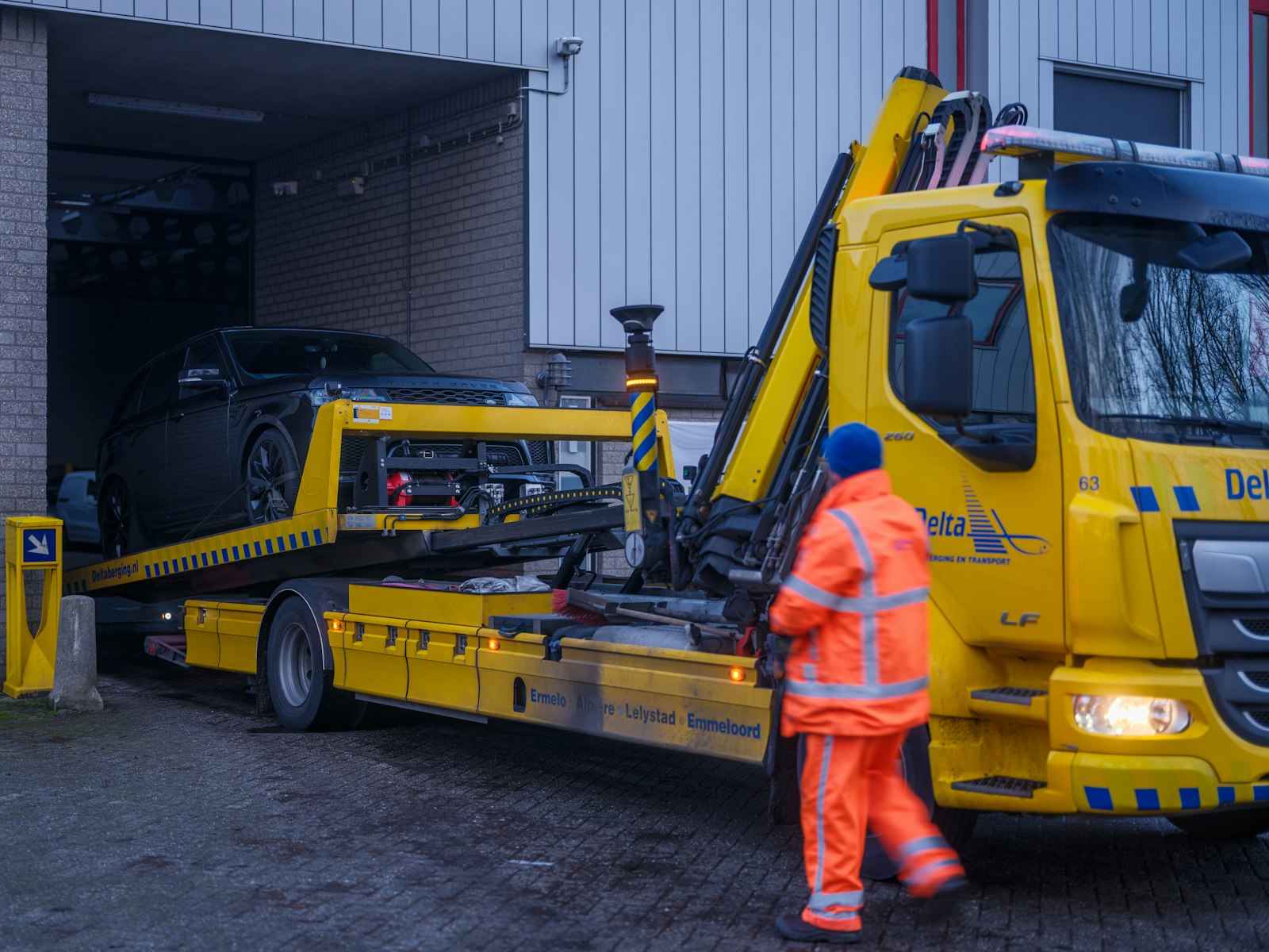 Professional recovery driver preparing a flatbed vehicle